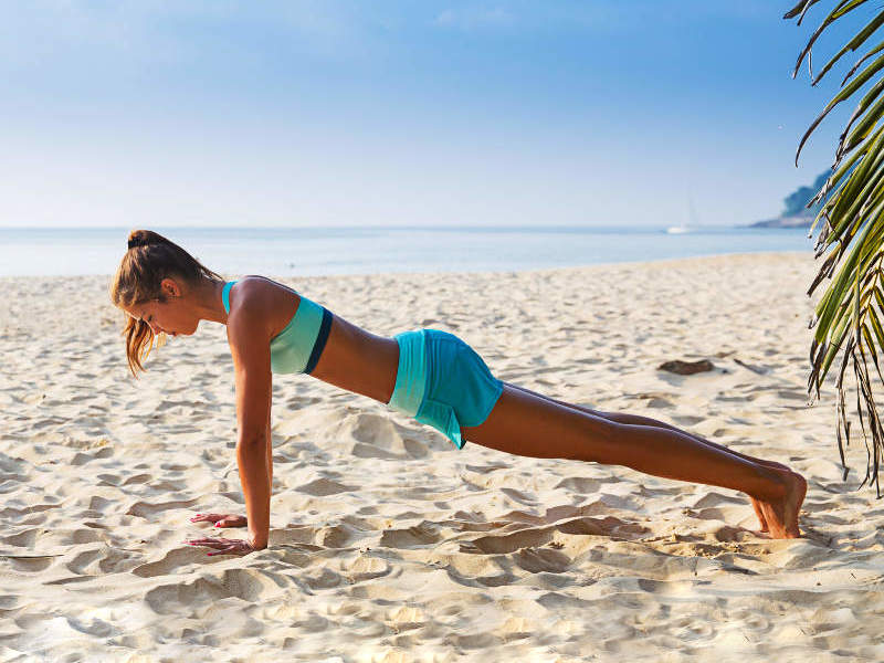Woman Doing Yoga Plank on Beach