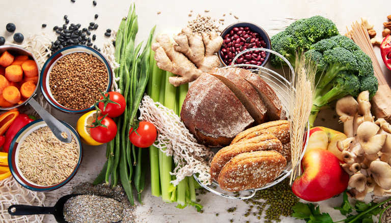 Assorted high-fiber foods including beans, lentils, bread, and vegetables.