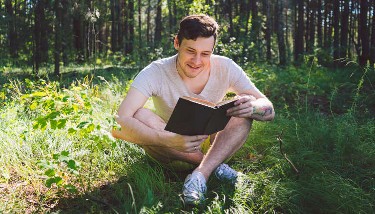 Man reading outside in nature.