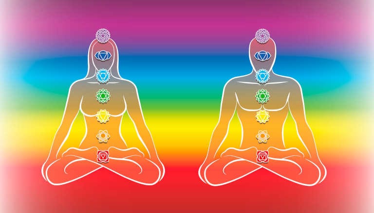 Man and woman silhouettes with seven chakras against rainbow background.