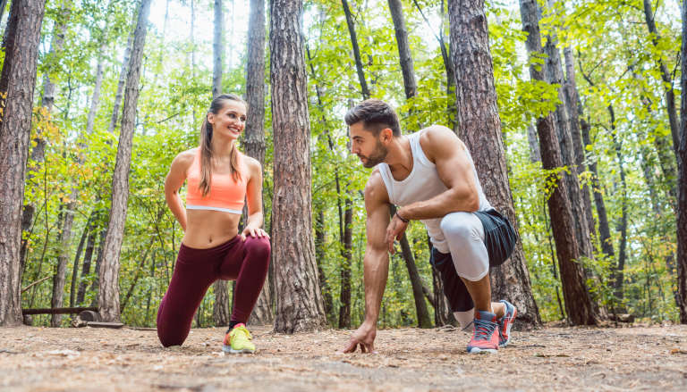 Couple warming up and exercising out in nature.