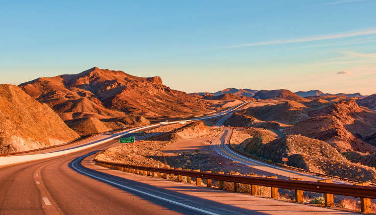 Winding mountain road bathed in warm golden light, symbolizing a transformative journey.