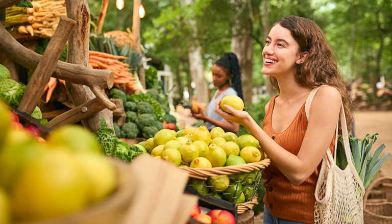 Woman shopping for vegetables and fruit at a farmer's market.